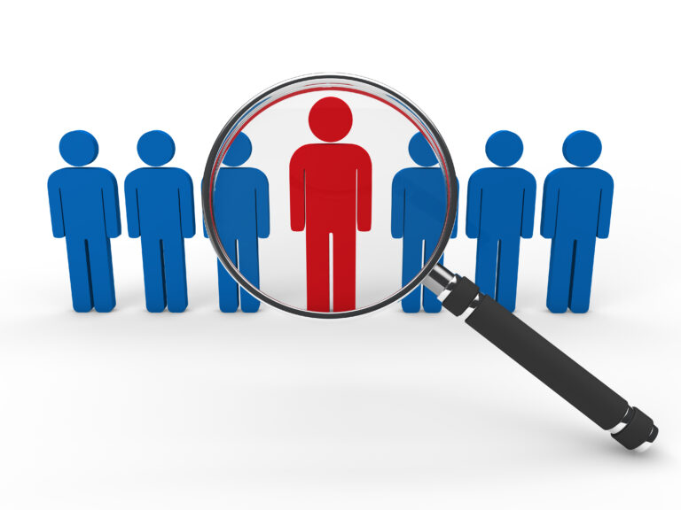 Magnifying glass highlighting a standout candidate among multiple people icons – concept of recruitment and talent selection